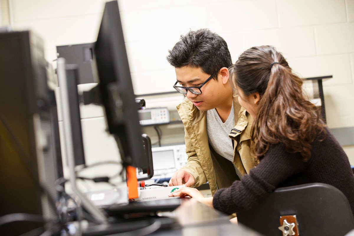 Two students around computer