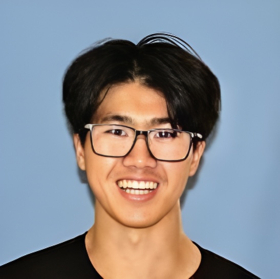 Close-up portrait of a smiling person with black hair and glasses, against a blue background.