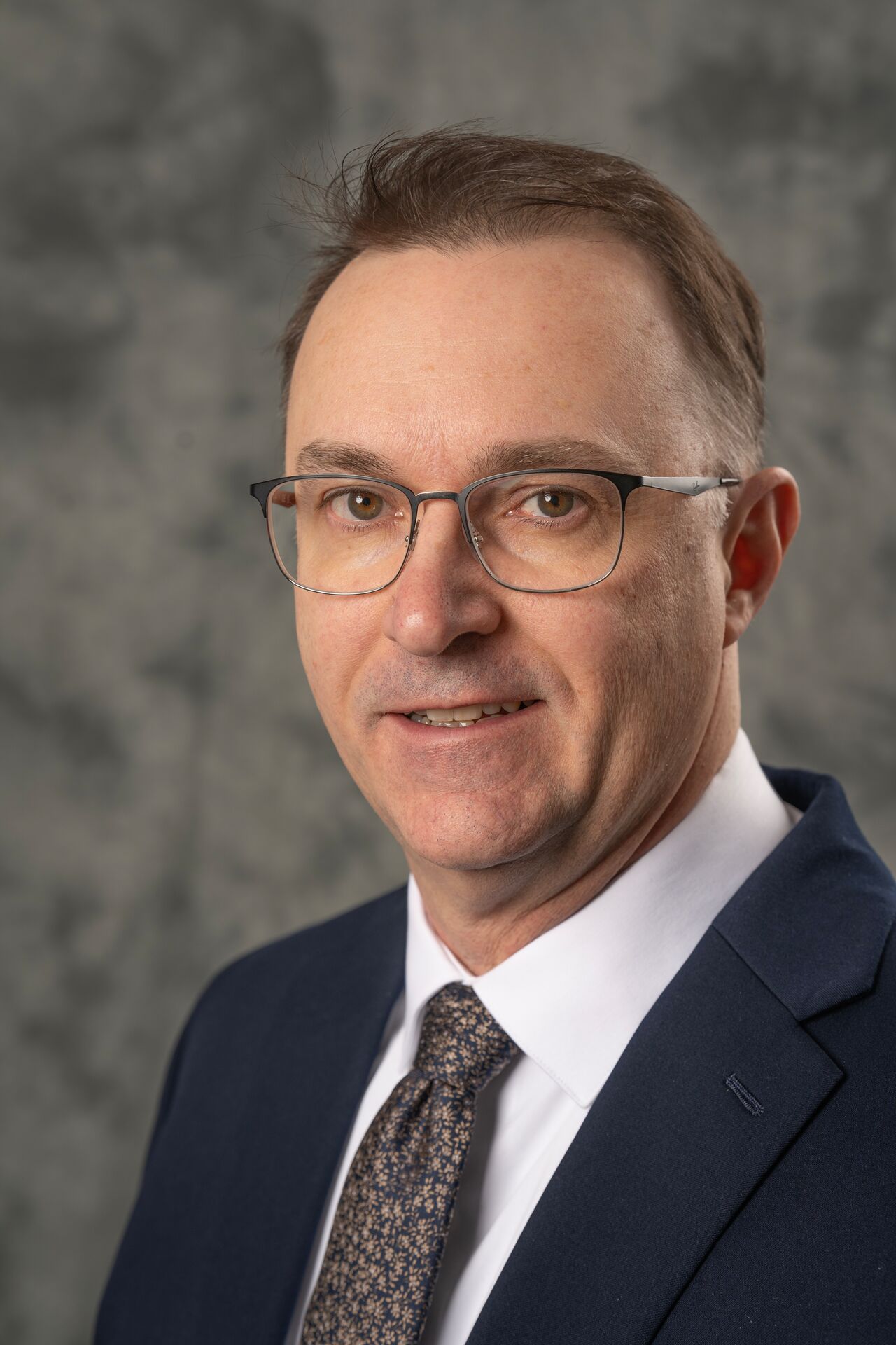 man in glasses and a suit smiling