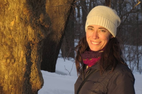 Carolyn Hall standing next to a tree in the snow